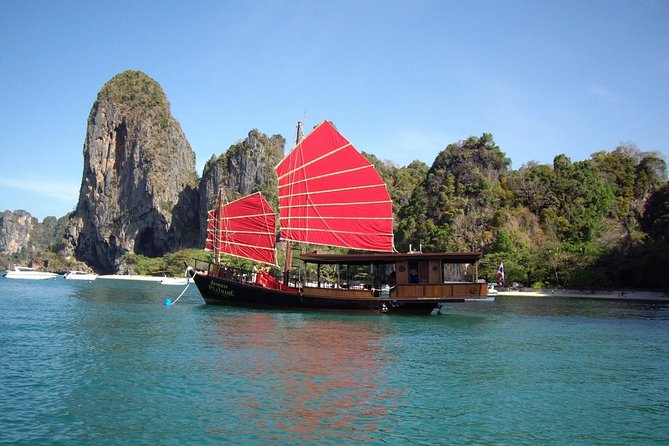 A longtail boat anchored under limestone karsts in Krabi