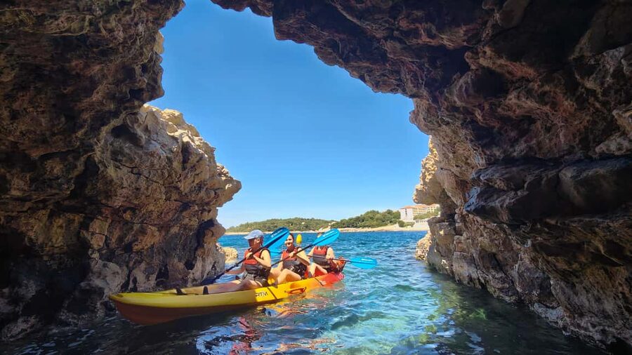 Pula: Cave Kayak Tour, Snorkeling and Island Jumping - Entering the pigeon cave and seeing the canyon